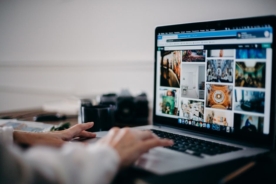 person searching TV options laptop