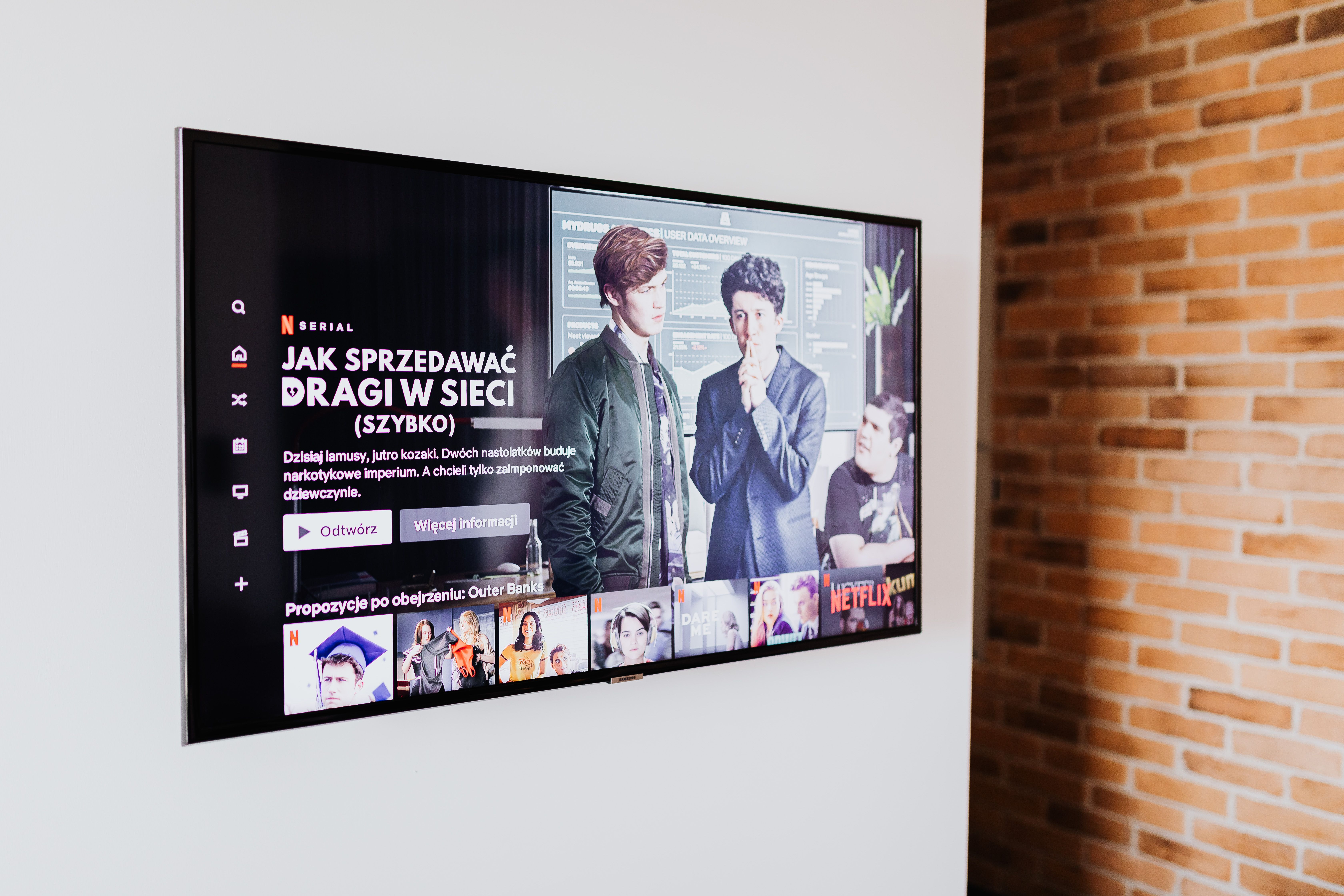 Smart TV mit IPTV-Streaming-App — wandmontierter Fernseher mit Serien-Übersicht